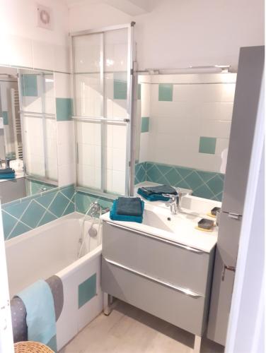 une salle de bain avec une baignoire et un lavabo et une baignoire dans l'établissement Villa club Sanary dans résidence fermée et arborée 10min a pied de la plage, à Sanary-sur-Mer