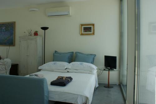 a bedroom with a bed with two pillows and a television at La mia terrazza sul mare - Mared'aMare in Bari