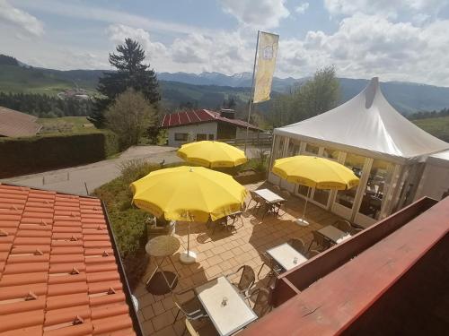 a group of yellow umbrellas on a patio at Helgas Landhotel in Oberreute