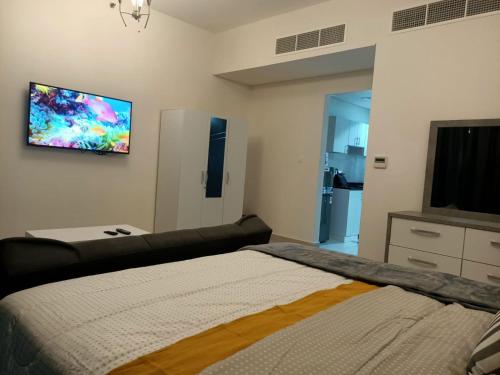 a bedroom with a bed and a flat screen tv at AL ALKEEM HEIGHTS in Ras al Khaimah