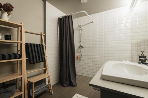 een badkamer met een wastafel en een douche bij Newly renovated Latvian farm house in Kraujas