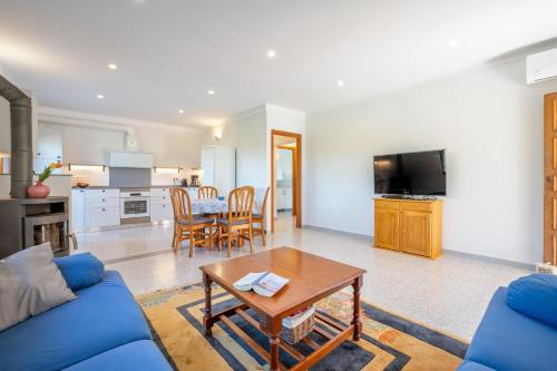 a living room with a blue couch and a table at Casa Mediterranea Invierno in Cala Llombards