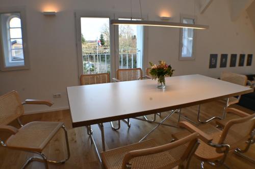 a table with chairs and a vase of flowers on it at Heuboden in Geschendorf