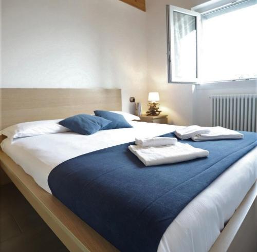 ein Schlafzimmer mit einem großen Bett mit Handtüchern darauf in der Unterkunft Apartments Camping Italia' 90 in Domaso