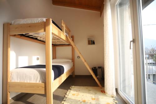 a bunk bed in a small room with a window at Apartments Camping Italia' 90 in Domaso