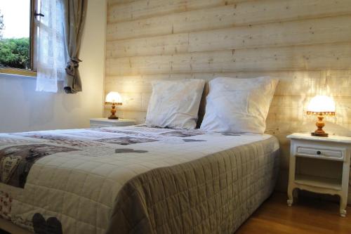 a bedroom with a large bed with two night stands at Gîte 1804 Montagnes du Jura avec Spa et Sauna classé 3 étoiles in Foncine-le-Haut