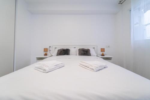 阿利坎特的住宿－Myflats Premium Teatro，一张白色的床,上面有两条毛巾