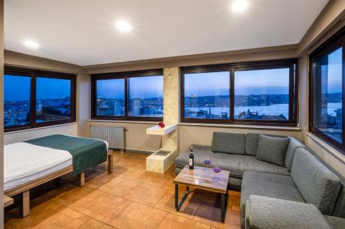 Zimmer mit Sofa, Bett und Fenstern in der Unterkunft The Pera Hotel in Istanbul