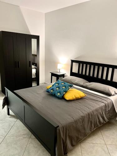 a bedroom with a large bed with yellow pillows at Mondello front beach in Palermo