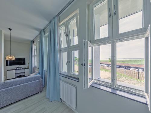 uma sala de estar com janelas grandes e um sofá em Panorama-Utkiek em Wustrow
