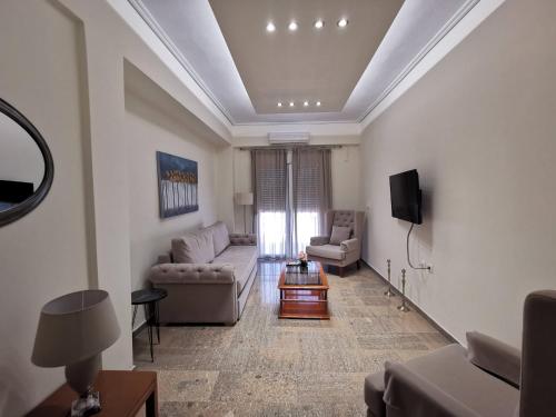 a living room with two couches and a tv at NAFPAKTOS Beach luxury Suites in Nafpaktos