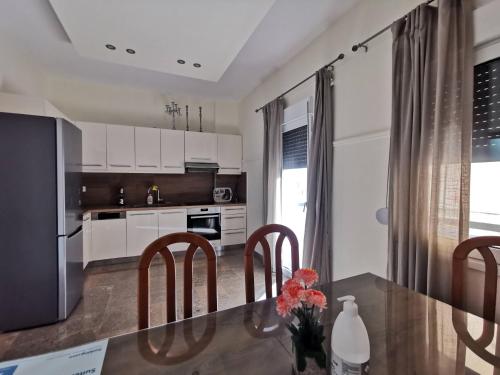 a kitchen with a table with chairs and a counter top at NAFPAKTOS Beach luxury Suites in Nafpaktos