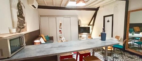 a living room with a table and a television at Résidence LE11B in Uzerche