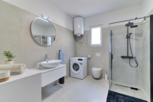a bathroom with a sink and a washing machine at Apartment Luka in Senj