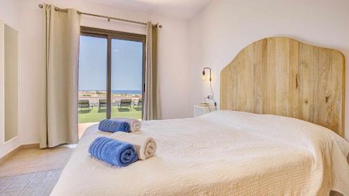 Un dormitorio con una cama grande con toallas. en Villa Vento by Calima Villas, en Costa de Antigua
