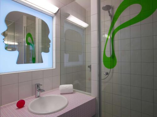 ein Bad mit einem Waschbecken und einer Glasdusche in der Unterkunft prizeotel Bremen-City in Bremen