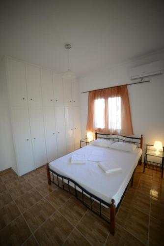 a bedroom with a large bed and a window at Aetos House Exanthia Village in Exanthia