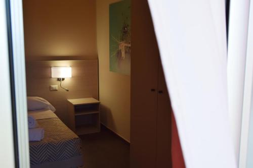 a small bedroom with a bed and a lamp at Hotel La Siesta in Torino di Sangro