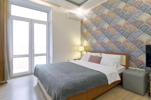 キーウにあるАпартаменты с тремя спальнями ул Бассейная Дворец Спорта Олимпийскаяの壁画のあるベッドルーム1室(大型ベッド1台付)