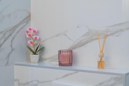 a white shelf with two vases and flowers on it at Center De Lux Studios “ Zara “ in Split