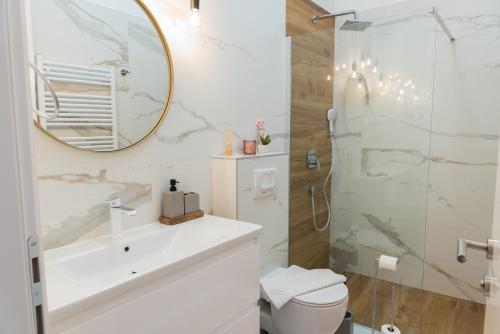 a bathroom with a sink and a shower with a mirror at Center De Lux Studios “ Zara “ in Split