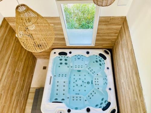 a bath tub in a room with a window at Les Jardins du Castelas - Domaine et Spas in Uchaux