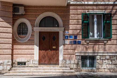 a building with a wooden door and two windows at Center De Lux Studios “ Zara “ in Split