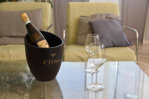 a bottle of wine in a bucket on a table with two glasses at Hotel La Siesta in Torino di Sangro