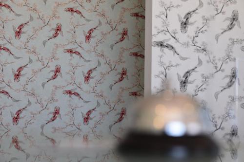 a bathroom with a wallpaper with drawings of red kites at Hotel La Siesta in Torino di Sangro