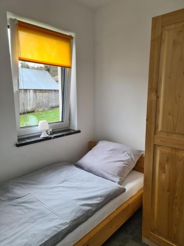 a bedroom with a bed and a window at Domek pod Złotym Groniem in Istebna