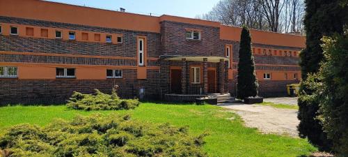 a large brick building with a yard in front of it at Motel Sportowy OSiR Jawor in Jawor