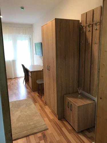 a room with a large wooden cabinet and a desk at Apartmani & SPA Matin Breg in Jošanička Banja