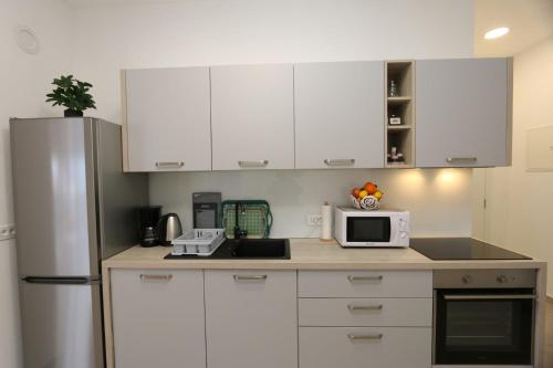 a kitchen with white cabinets and a white refrigerator at Apartments Zabcic in Soline