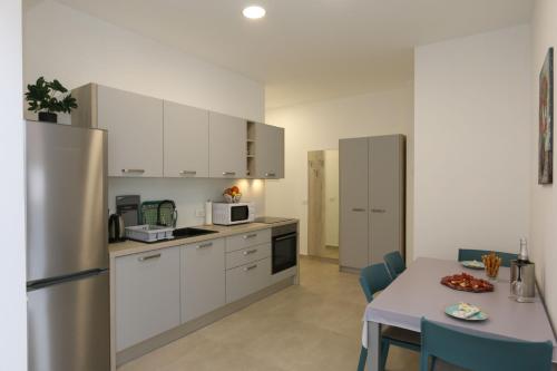 a kitchen with white cabinets and a table with a plate of food at Apartments Zabcic in Soline