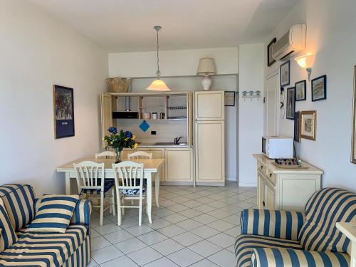 a living room with a table and chairs and a kitchen at Casa sul mare- House on the sea- VERSILIA in Marina di Pietrasanta