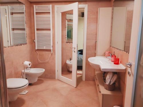 a bathroom with a toilet and a sink and a mirror at Le Pizzocchere in Venice