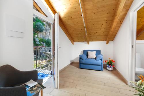 a living room with a blue chair and a wooden ceiling at Eterea Charming Suites in Sorrento