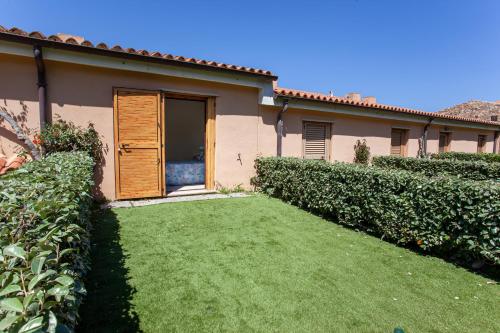a house with a lawn in front of it at Porto Coda Cavallo Beach House a 300 mt dal mare, con terrazza panoramica in San Teodoro