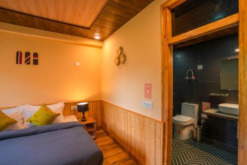 a small room with a bed and a bathroom at Zostel Manali, Vashisht in Vashisht