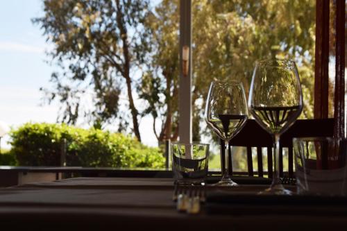 two glasses of wine sitting on a table with a window at Hotel La Siesta in Torino di Sangro