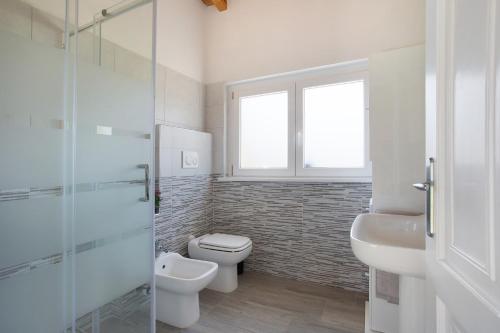 a bathroom with a toilet and a glass shower at Casina Bianca in Lurate Caccivio