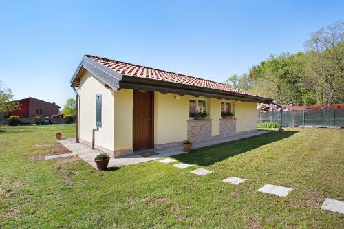 a small yellow house with a grassy yard at Casina Bianca in Lurate Caccivio