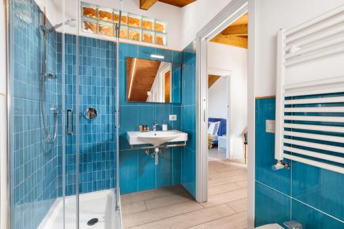 y baño azul con lavabo y ducha. en Eterea Charming Suites, en Sorrento