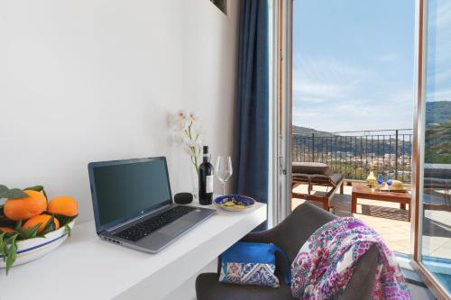 a laptop computer sitting on a white desk next to a window at Eterea Charming Suites in Sorrento
