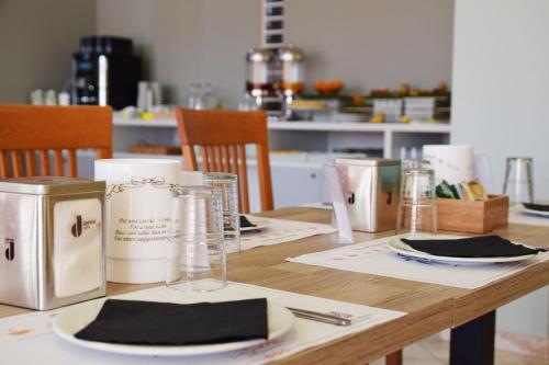a wooden table with plates and napkins on it at Hotel La Siesta in Torino di Sangro