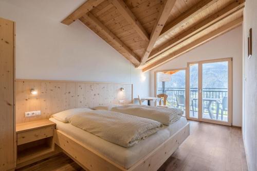 ein Schlafzimmer mit einem großen Bett und einem Balkon in der Unterkunft Thusnelda Apartment B in Seis am Schlern