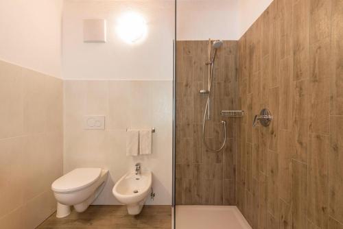 ein Bad mit einer Dusche, einem WC und einem Waschbecken in der Unterkunft Thusnelda Apartment B in Seis am Schlern