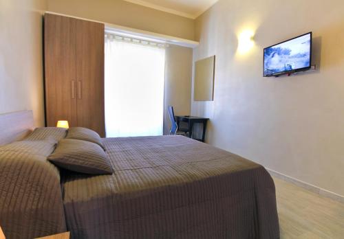 a bedroom with a bed with a television on the wall at San Pietro's Home - Guesthouse in Rome