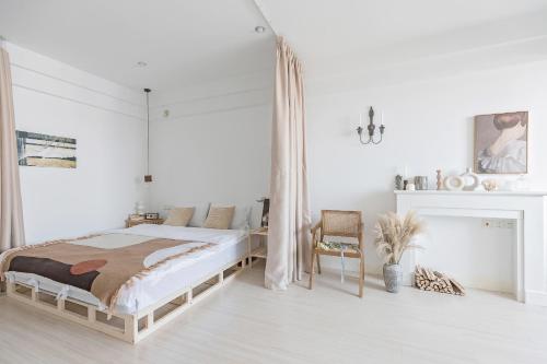 a white bedroom with a bed and a chair at King'sLandind BnB in Chongqing
