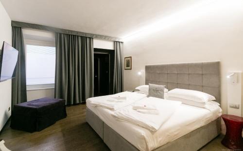 a bedroom with a large bed with two towels on it at Boutique Exclusive B&B in Trento